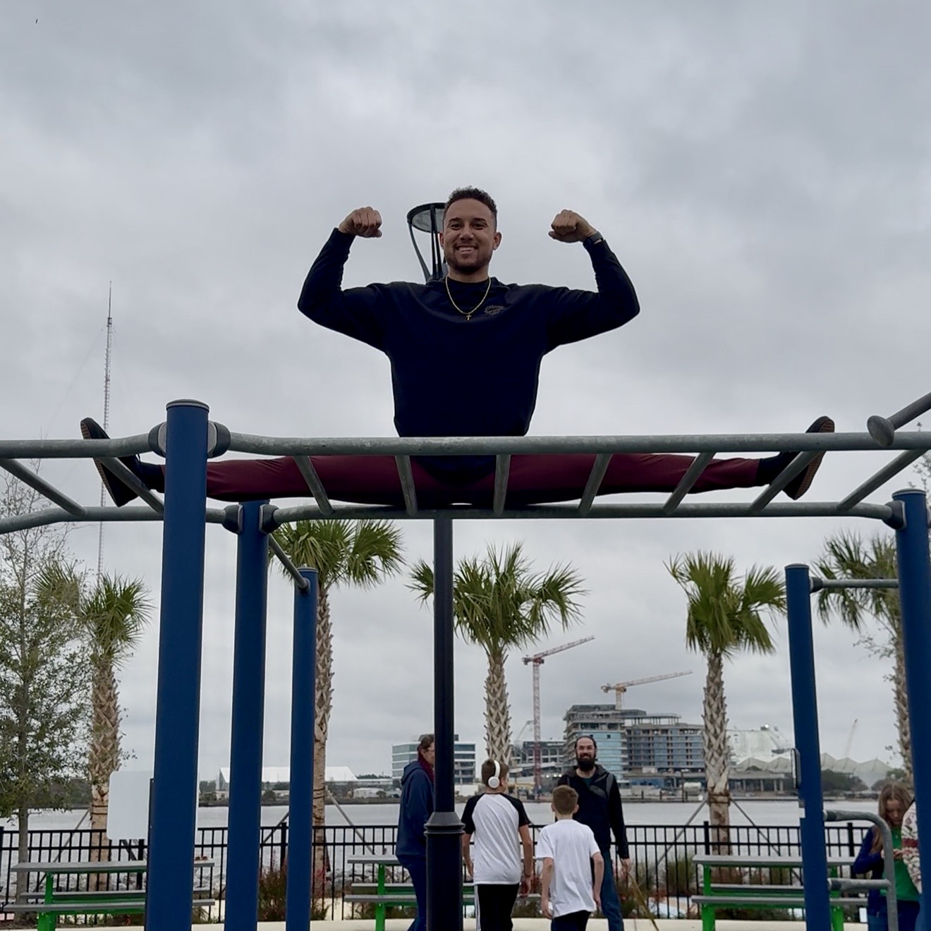 A JaxBars athlete celebrating above the bars with the community nearby